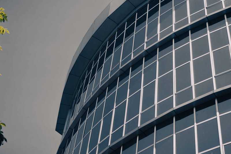 Fasad kaca melengkung sebuah gedung perkantoran.